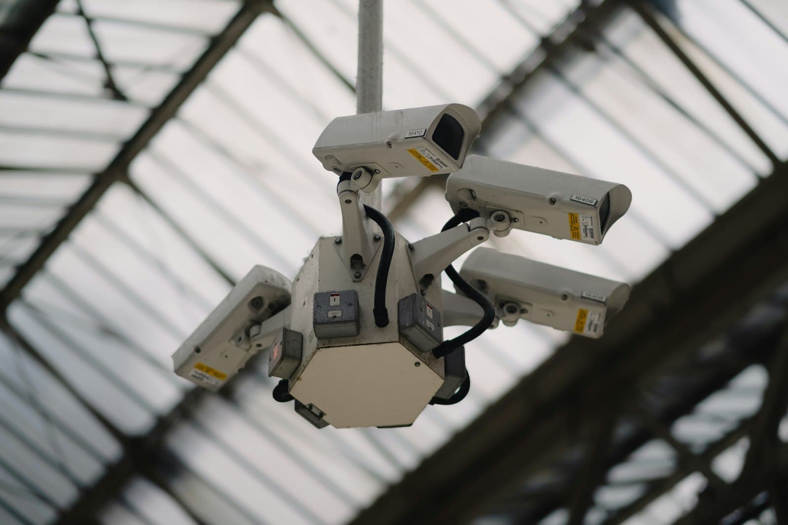 Cluster of multiple surveillance cameras mounted to a ceiling for full-coverage CCTV monitoring
